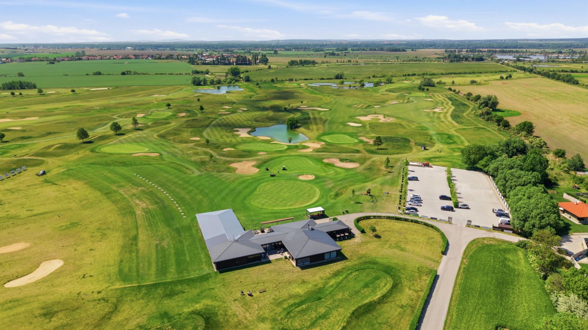 Letecký záber golfového areálu s klubovňou a parkoviskom